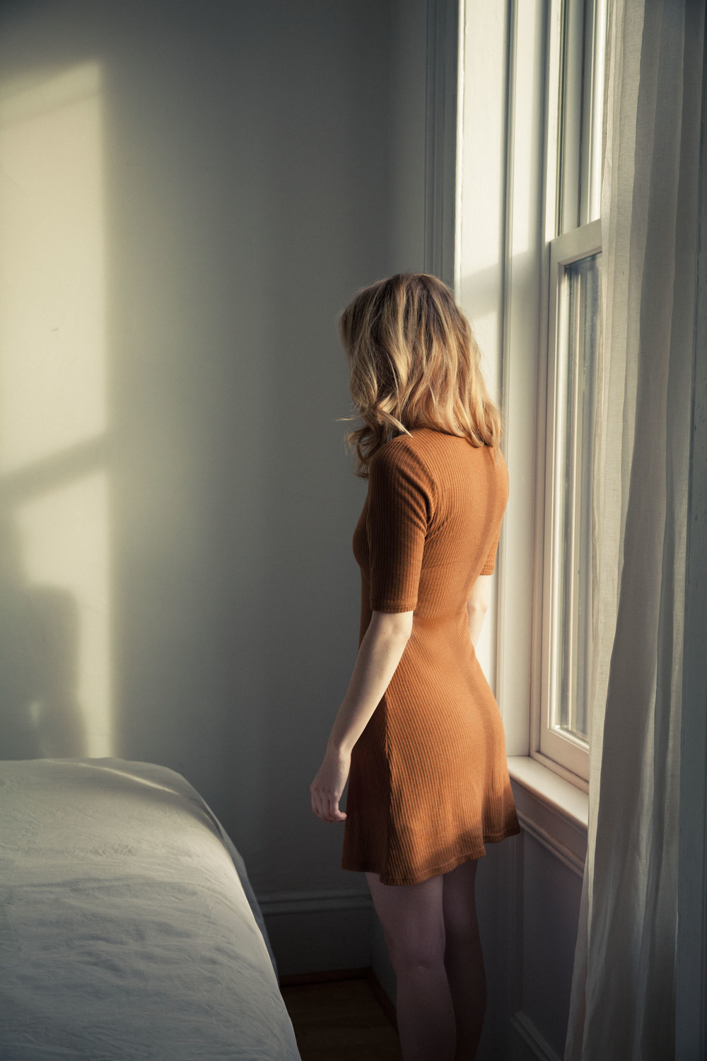 1000x1500, 277 Kb / блондинка, девушка, бежевое, платье, стоит, спиной, кровать, окно, свет